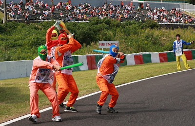 маршалы Сузуки размахивают флагами на Гран-при Японии 2012