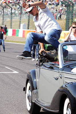 Михаэль Шумахер выпрыгивает из машины во время парада пилотов на Сузуке на Гран-при Японии 2011