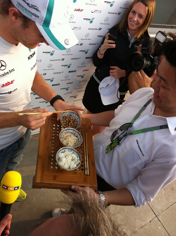 Нико Росберг с китайскими палочками пробует китайскую еду на Гран-при Китая 2011