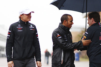 Нико Росберг и Льюис Хэмилтон приветствуют Кристиана Хорнера с зонтиком на Гран-при Кореи 2011