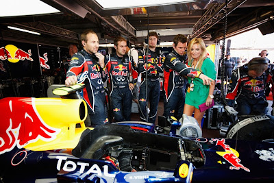 Джерри Холливел в боксах команды Red Bull изучает болид Формулы-1 с механиками перед гонкой на Гран-при Монако 2011