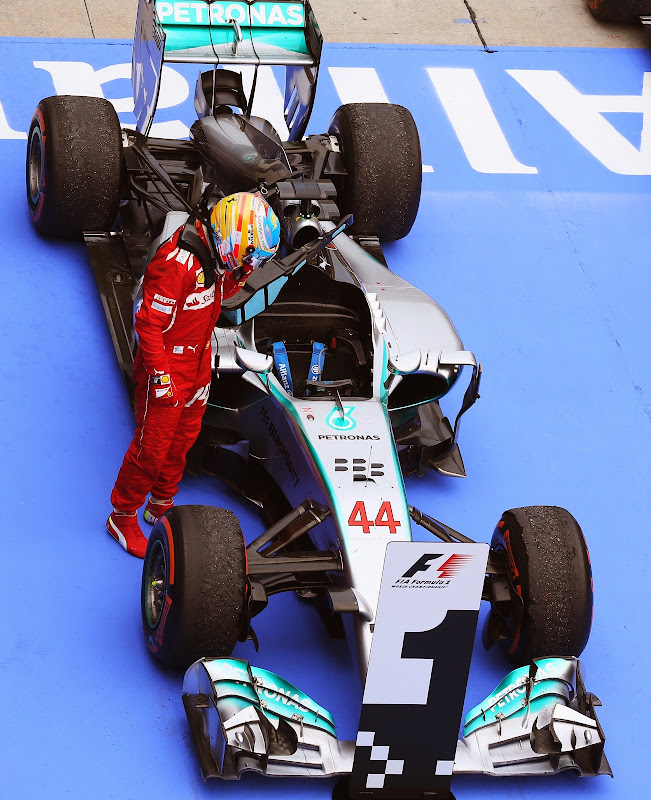 Фернандо Алонсо разглядывает болид Mercedes после финиша Гран-при Малайзии 2014