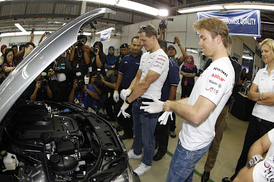 Михаэль Шумахер и Нико Росберг одевают белые перчатки на сборке Mercedes в Куала-Лумпур перед Гран-при Малайзии 2012