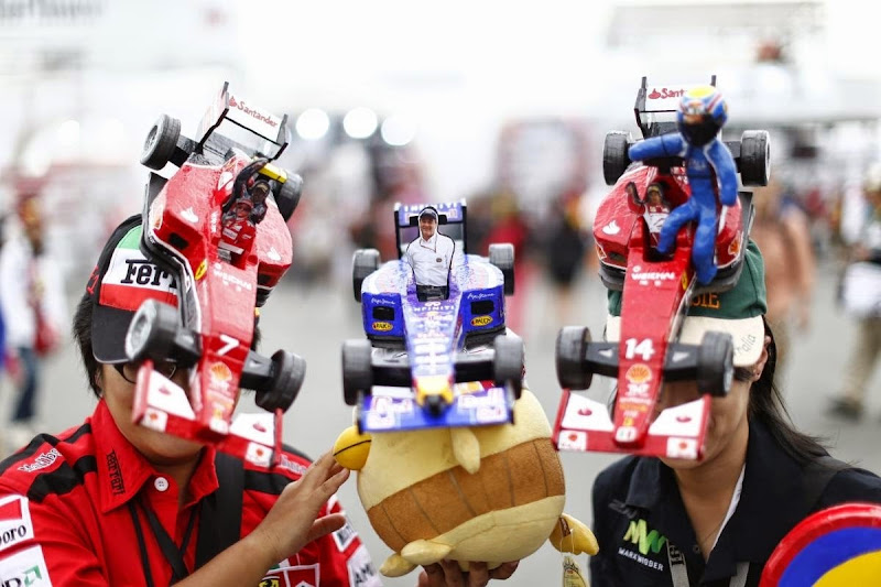 болельщики в оригинальных кепках Ferrari и Red Bull на Гран-при Японии 2014