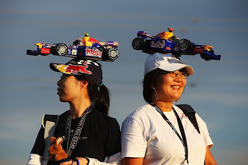 болельщицы Марка Уэббера и Себастьяна Феттеля с болидами Red Bull на кепках на Гран-при Японии 2012