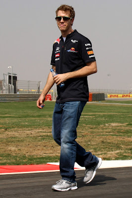 Себастьян Феттель с забавным лицом идет по трассе Буддх на Гран-при Индии 2011