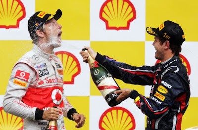 Себастьян Феттель обливает Дженсона Баттона шампанским на подиуме Гран-при Бельгии 2011