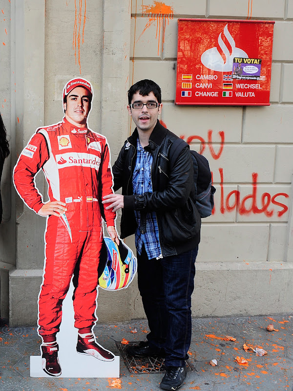 студент с фигурой Фернандо Алонсо на фоне испанского банка Santander в Барселоне 21 ноября 2011