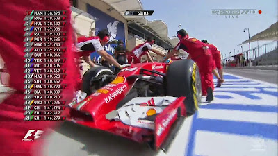 механики Ferrari отталкивают болид Фернандо Алонсо назад в боксы во время первой сессии свободных заездов на Гран-при Бахрейна 2014