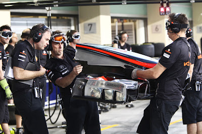 механики McLaren удивленно смотрят в передние антикрыло на Гран-при Абу-Даби 2011