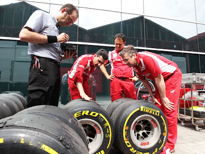 Андреа Стелла и механики Ferrari смотрят резину Pirelli на Гран-при Европы 2011
