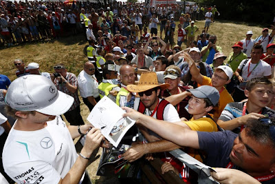 Нико Росберг раздает автографы на трибуне с болельщиками на Гран-при Венгрии 2013