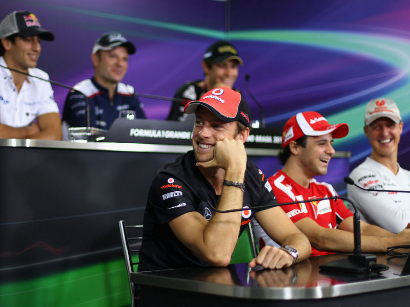 улыбающийся Дженсон Баттон отворачивается на пресс-конференции в четверг на Гран-при Бразилии 2011