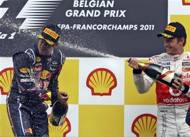 Дженсон Баттон направляет струю шампанского в голову Себастьяна Феттеля на подиуме Гран-при Бельгии 2011