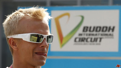 Хейкки Ковалайнен облизывается на фоне вывески Buddh International Circuit на Гран-при Индии 2011