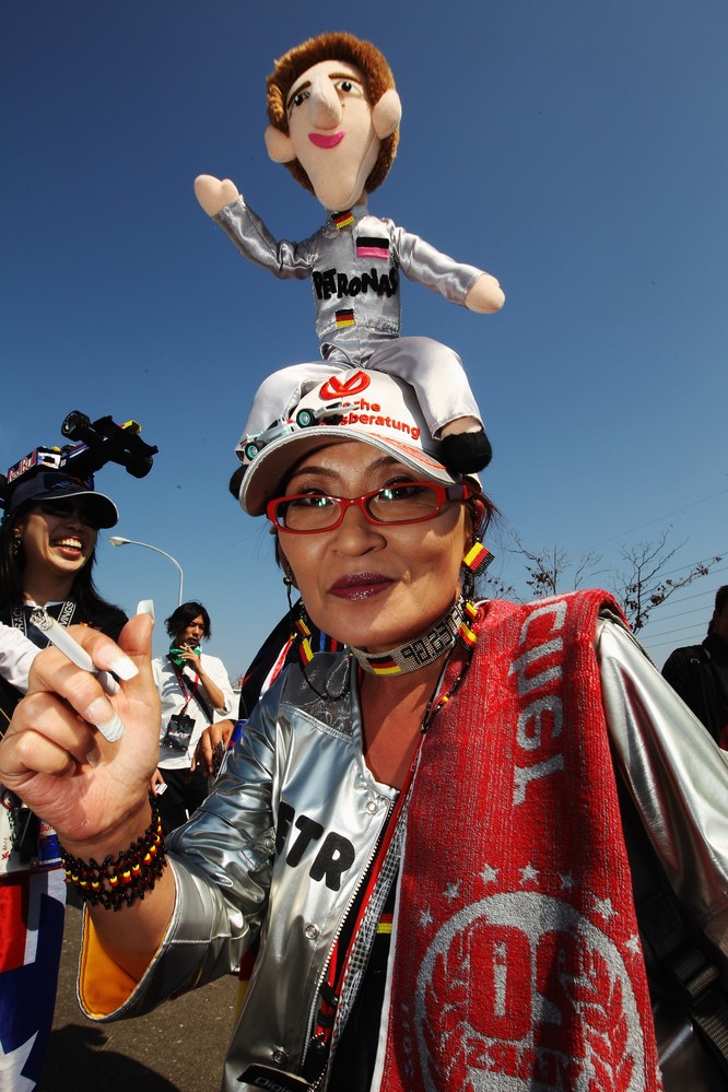болельщица Михаэля Шумахера с куклой ка кепке на Гран-при Японии 2011