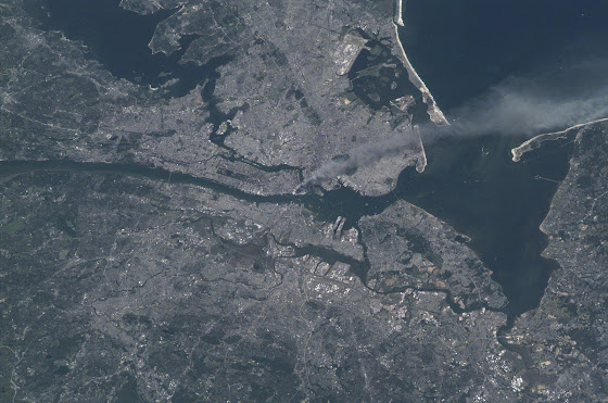 Visible from space, a smoke plume rises from the Manhattan area after two planes crashed into the towers of the World Trade Center. This photo was taken of metropolitan New York City (and other parts of New York as well as New Jersey) the morning of September 11, 2001. 