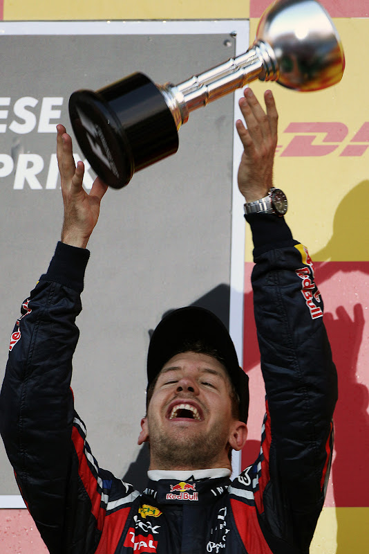 Себастьян Феттель подбрасывает свой трофей на подиуме Гран-при Японии 2011