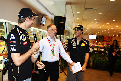 ведущий разнимает Виталия Петрова и Бруно Сенну на автограф-сессии Гран-при Сингапура 2011