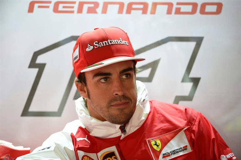 Фернандо Алонсо украдкой тянется к ботинку Puma в боксах Ferrari на Гран-при Монако 2014