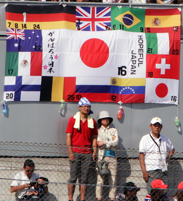 болельщики Камуи Кобаяши с флагами всех стран на трибунах Сузуки на Гран-при Японии 2011