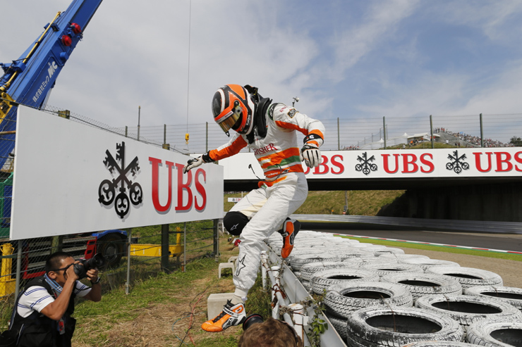 Нико Хюлькенберг спрыгивает с ограждения на трассе Сузука на Гран-при Японии 2012