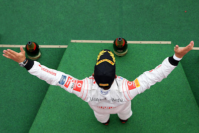 Льюис Хэмилтон празднует свою победу на подиуме Нюрбургринга на Гран-при Германии 2011