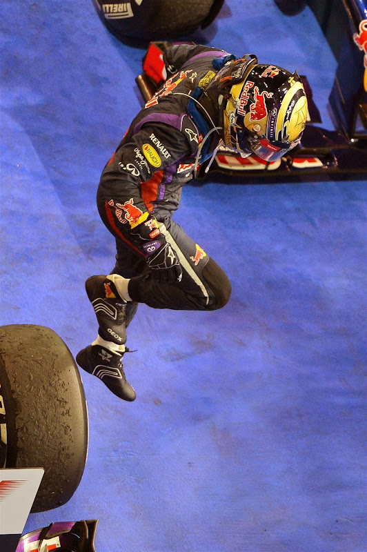 Себастьян Феттель спрыгивает со своего Red Bull после победы на Гран-при Абу-Даби 2013