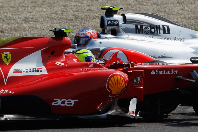 Дженсон Баттон на McLaren проезжает мимо развернувшегося Фелипе Массы на Ferrari на Гран-при Италии 2011