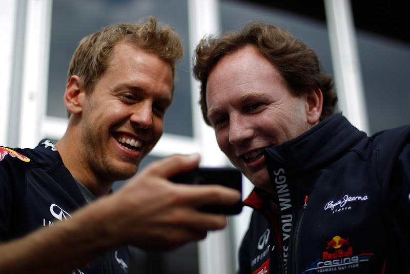 Себастьян Феттель показывает что-то Кристиану Хорнеру на своем телефоне на Гран-при Канады 2012