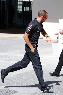 Льюис Хэмилтон бежит и смотрит на часы на Гран-при Абу-Даби 2011