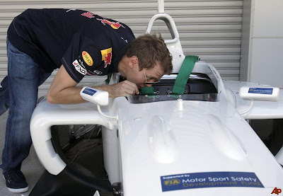 Себастьян Феттель заглядывает в кокпит болида FIA на Гран-при Японии 2011