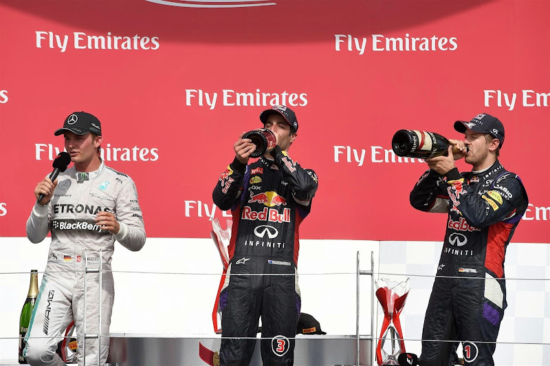 Нико Росберг дает интервью, а Даниэль Риккардо и Себастьян Феттель выпивают шампанское на подиуме Гран-при Канады 2014