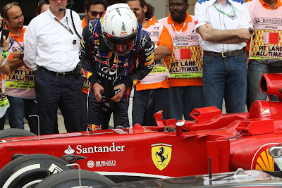 Себастьян Феттель разглядывает болид Ferrari после квалификации на Гран-при Бахрейна 2013