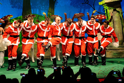 пилоты Ferrari в костюмах Санта-Клауса пляшут на сцене на рождественском мероприятии Ferrari для детей 18 декабря 2011
