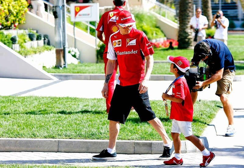 Кими Райкконен встречает маленького болельщика в паддоке Сахира на Гран-при Бахрейна 2014