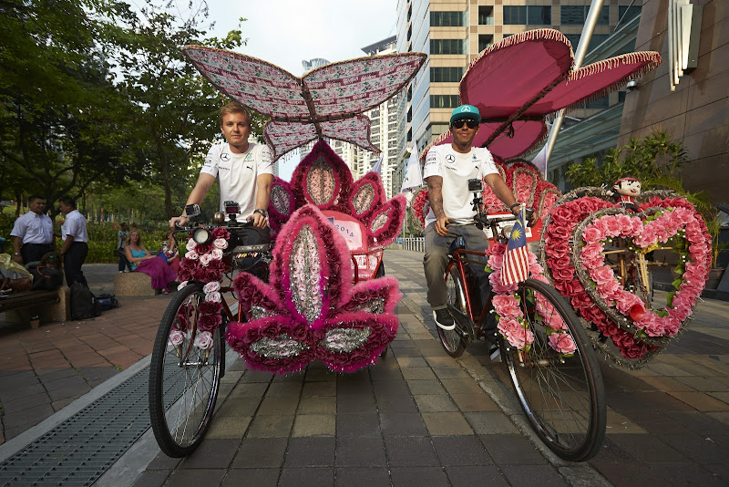 Нико Росберг и Льюис Хэмилтон катаются на цветочных велосипедах по Куала-Лумпуру перед Гран-при Малайзии 2014