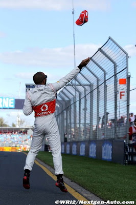 Льюис Хэмилтон бросает кепку болельщикам на трибунах Альберт-Парка на Гран-при Австралии 2012
