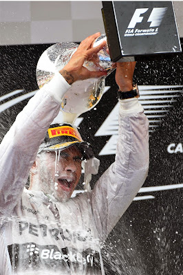 Льюиса Хэмилтона обливает себя шампанским из кубка на подиуме Гран-при Испании 2014