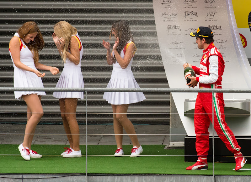 Фернандо Алонсо поливает шампанским девочек на подиуме Гран-при Бельгии 2013