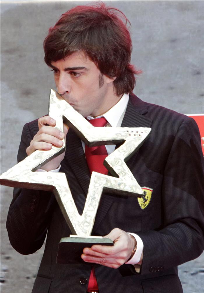 Фернандо Алонсо целует трофей в Мадриде 19 декабря 2011