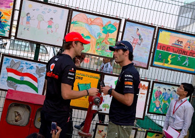 Дженсон Баттон и Марк Уэббер разговаривают на фоне рисунков на Гран-при Индии 2011