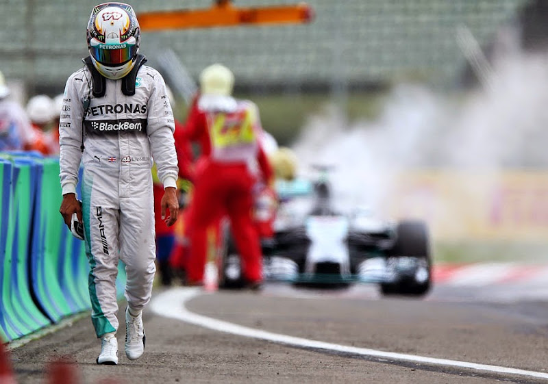 Льюис Хэмилтон на фоне горящего Mercedes на Гран-при Венгрии 2014