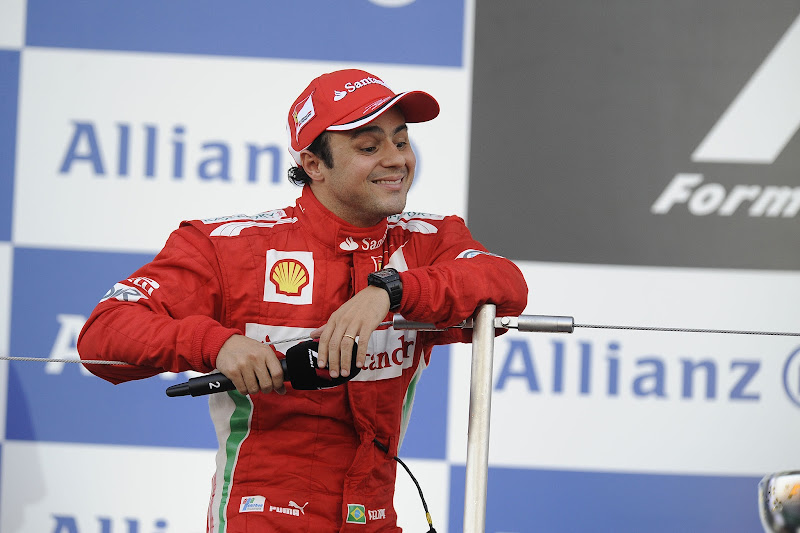 улыбающийся Фелипе Масса с микрофоном на подиуме Сузуки на Гран-при Японии 2012