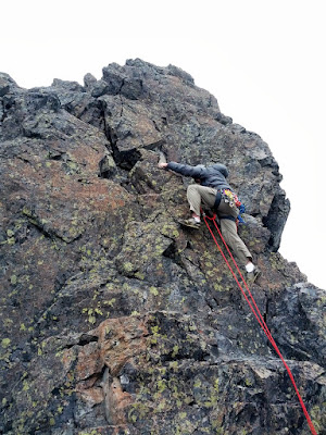 Justin moving past the piton and his one cam to reach the summit on the 5.6 standard route