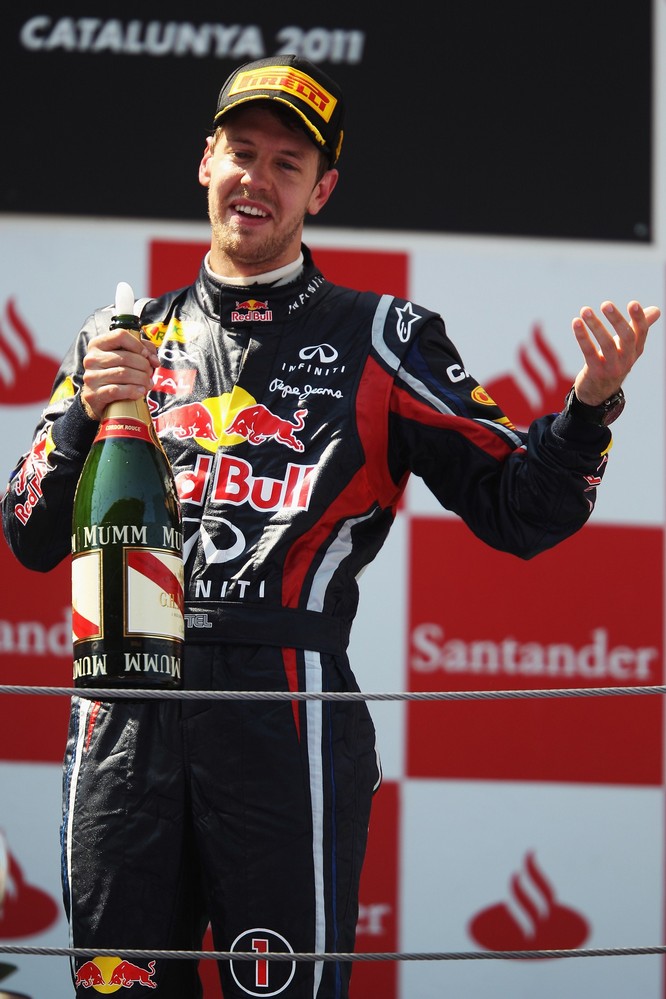 Себастьян Феттель на подиуме с бутылкой шампанского на Гран-при Испании 2011
