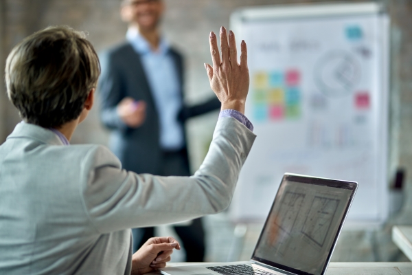 back-view-female-entrepreneur-raising-hand-answer-question-during-business-presentation-office 