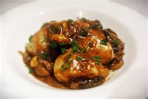 Coq Au Vin which is chicken (traditionally the dark meat) braised in red wine, bacon and mushrooms