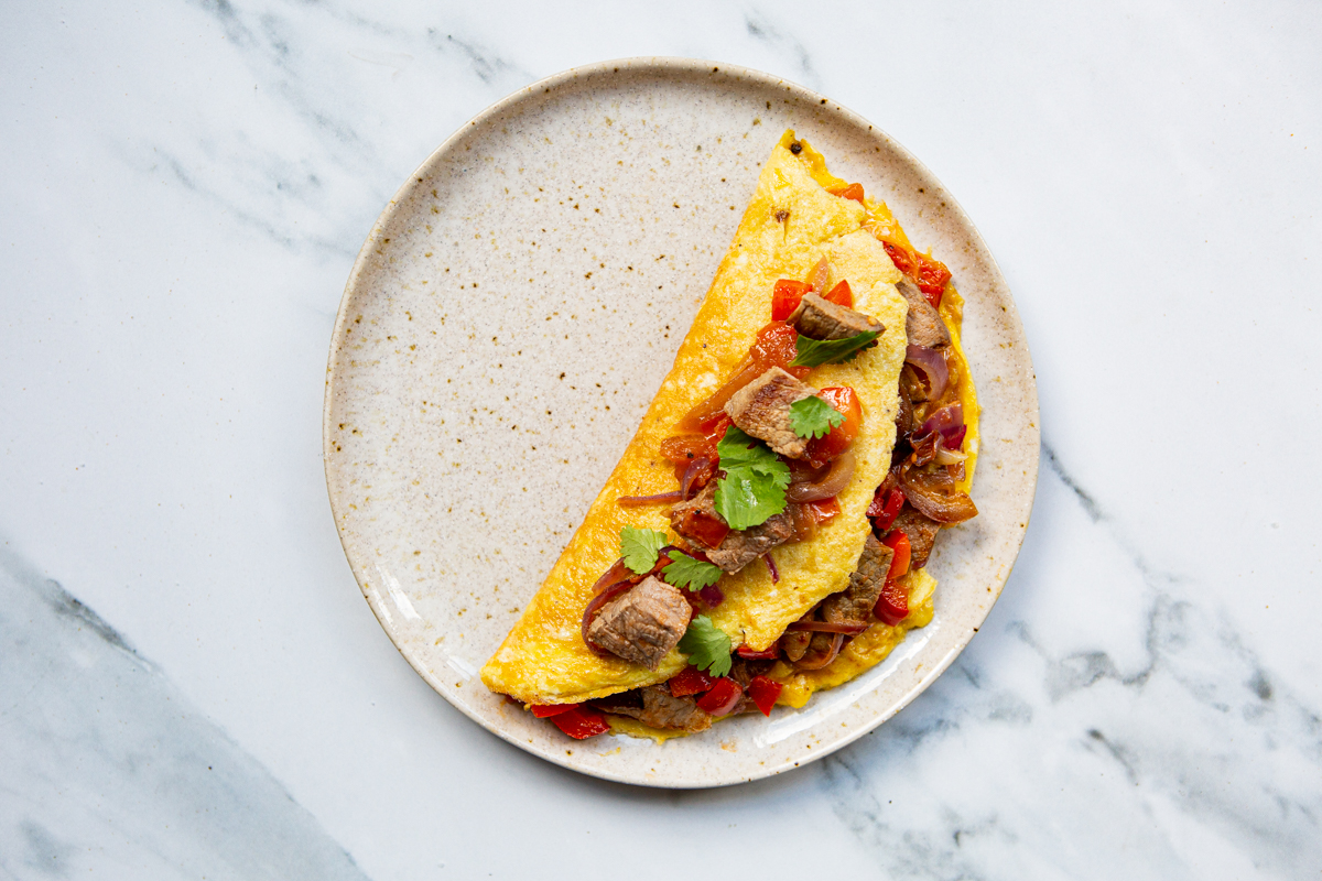 cooked steak omelette garnished with cilantro leaves