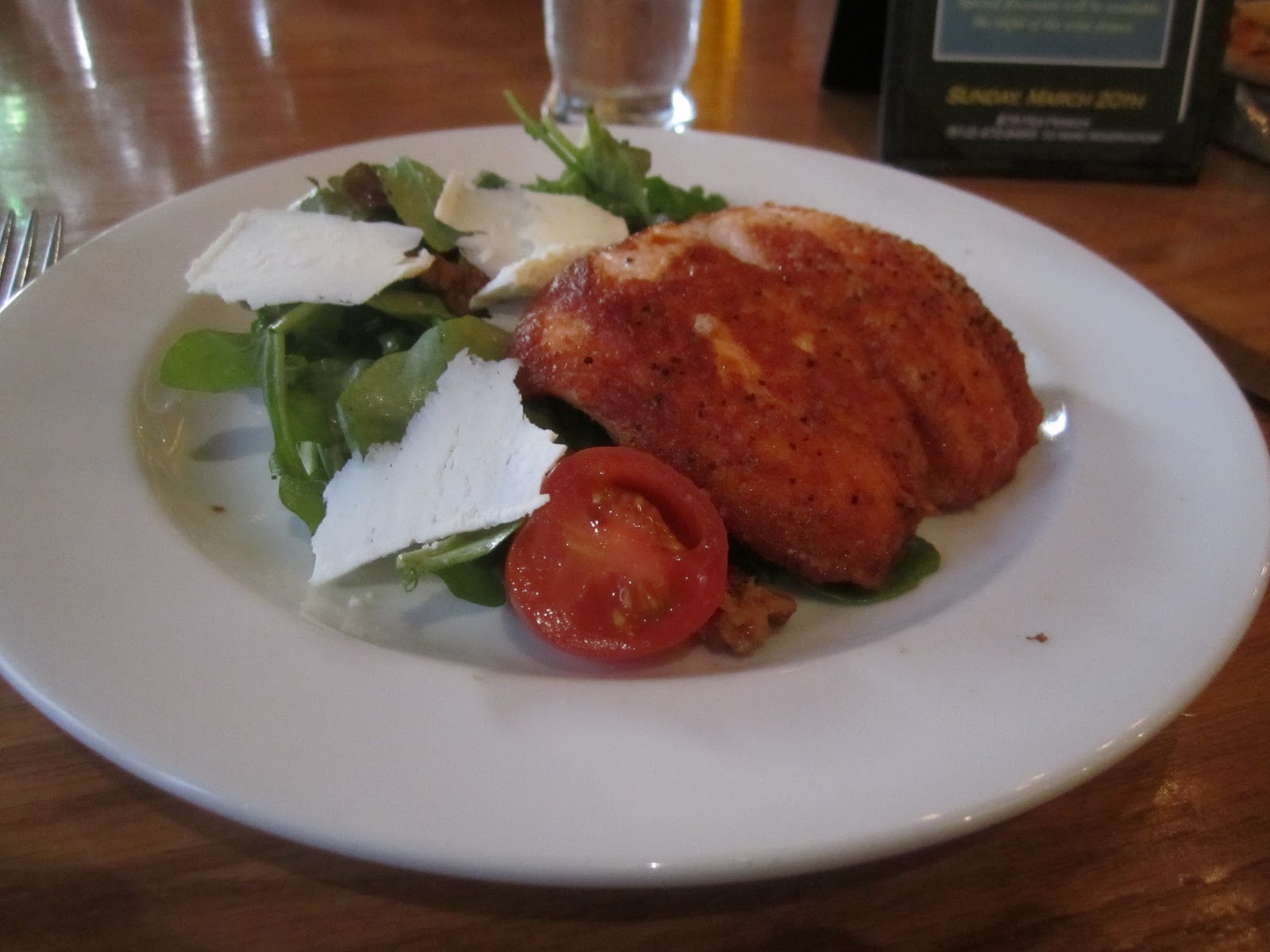 Cru House Salad generously topped with perfectly grilled salmon and an assortment of fresh vegetables.